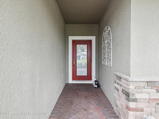 entrance to property featuring stucco siding