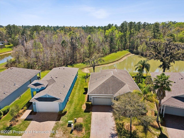 drone / aerial view with a water view and a view of trees