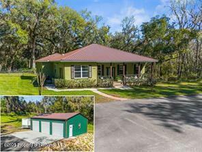 view of front of home with an outbuilding, a porch, a garage, driveway, and a front yard