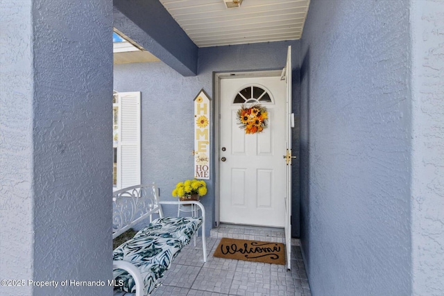 entrance to property featuring stucco siding