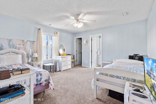 bedroom with visible vents, light colored carpet, ceiling fan, and a textured ceiling