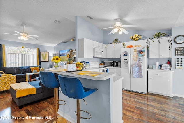 kitchen featuring light countertops, open floor plan, white cabinetry, white appliances, and a peninsula