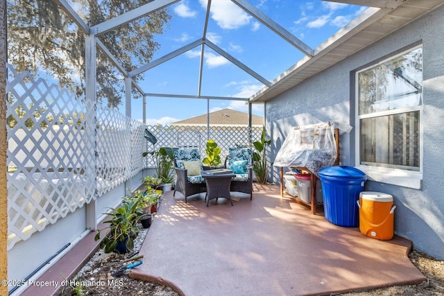 view of patio / terrace with glass enclosure and a fenced backyard