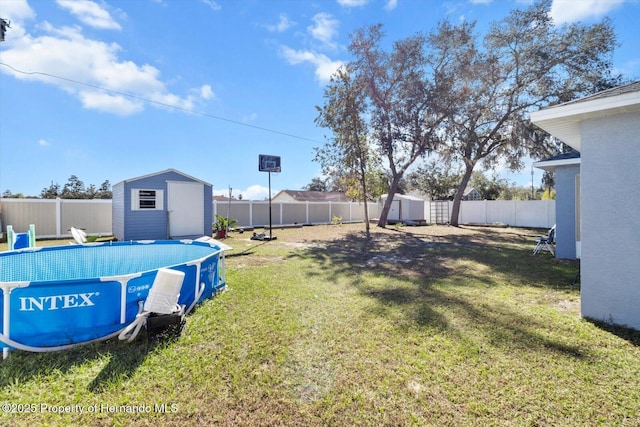 view of yard featuring a fenced in pool, a fenced backyard, an outdoor structure, and a storage shed