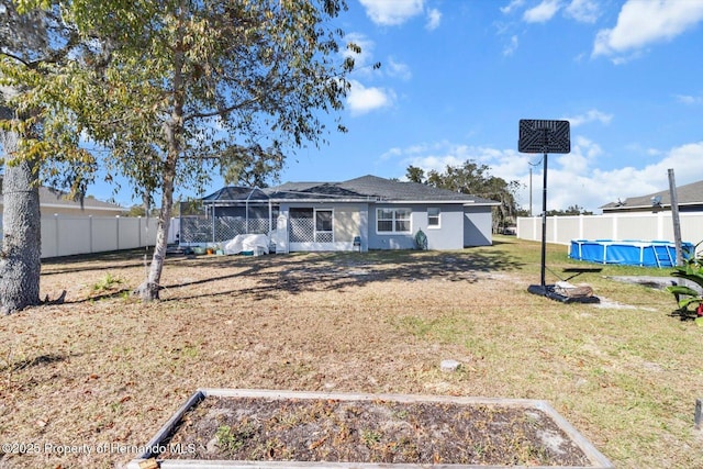 view of front facade with a fenced backyard, a vegetable garden, a fenced in pool, and a front yard