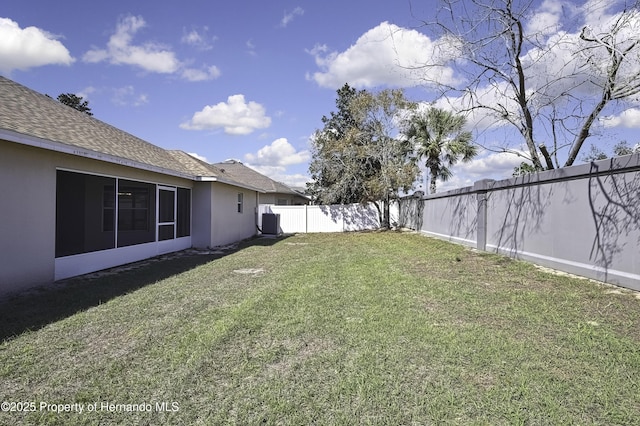 view of yard with a fenced backyard and central AC unit