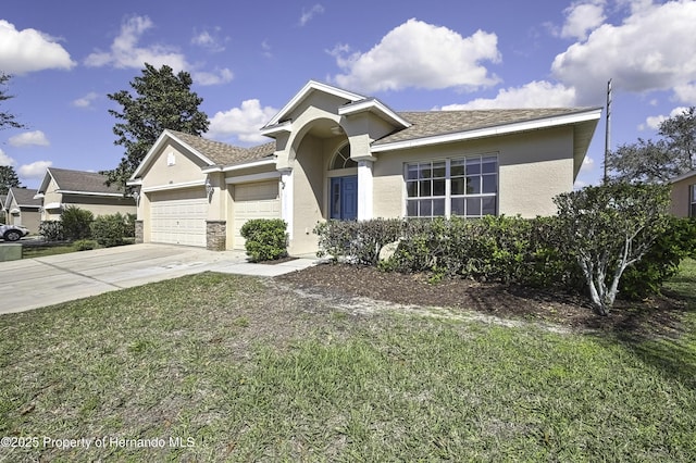 ranch-style house with driveway, a garage, a front lawn, and stucco siding