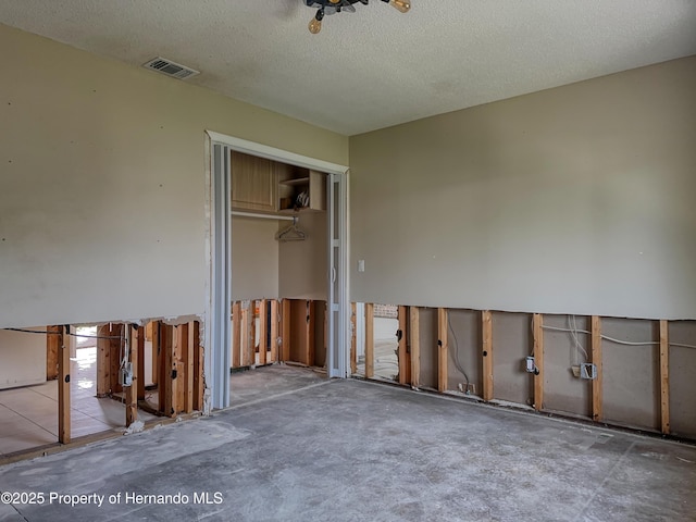 spare room featuring a textured ceiling and visible vents