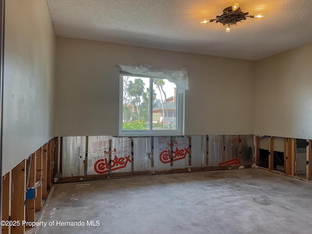 spare room featuring concrete floors and a textured ceiling