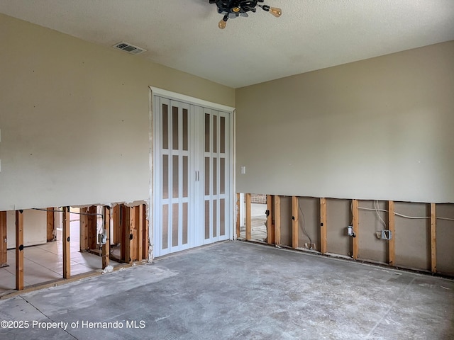 unfurnished room with visible vents and a textured ceiling