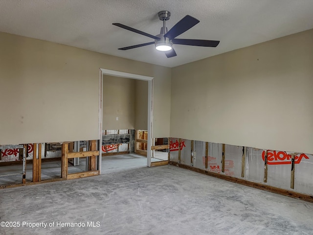 empty room with concrete flooring, ceiling fan, and a textured ceiling