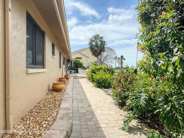 view of side of home featuring a patio area and stucco siding