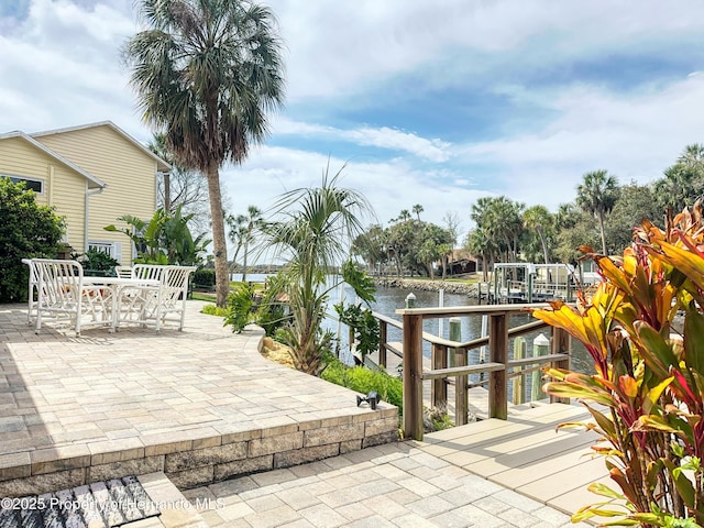 view of patio with a water view, outdoor dining area, and an outdoor bar