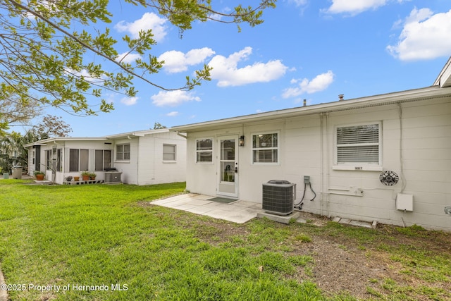 rear view of property with a yard and central air condition unit