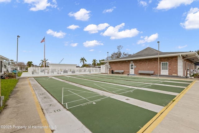 view of home's community featuring fence and shuffleboard