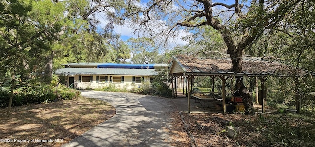 view of front facade with concrete driveway and metal roof