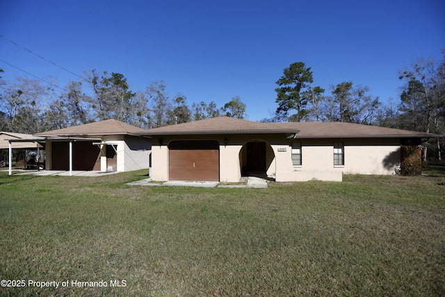 rear view of house featuring a lawn and stucco siding