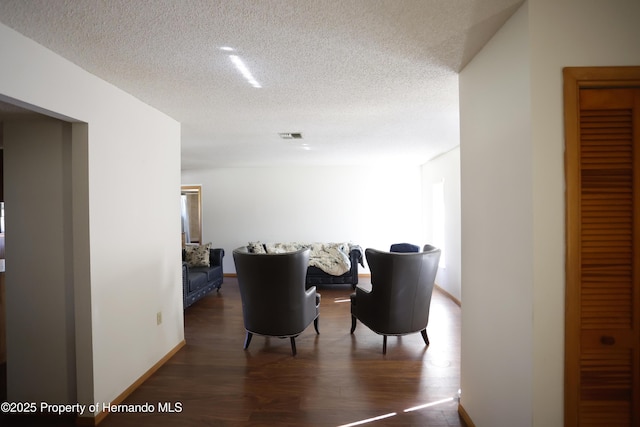 dining area with baseboards, visible vents, dark wood finished floors, and a textured ceiling