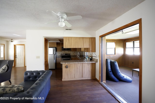 kitchen featuring visible vents, appliances with stainless steel finishes, open floor plan, a peninsula, and light countertops