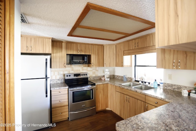 kitchen featuring black microwave, a textured ceiling, a sink, stainless steel range with electric cooktop, and freestanding refrigerator