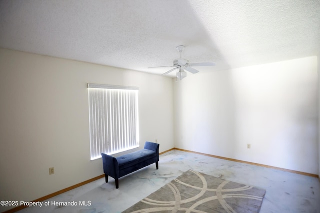 unfurnished room with a textured ceiling, ceiling fan, baseboards, and light colored carpet