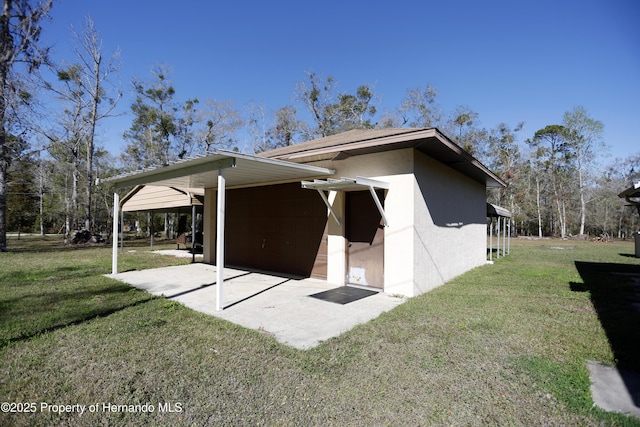 exterior space with a patio, a lawn, and stucco siding