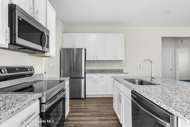 kitchen featuring stainless steel appliances, a sink, visible vents, white cabinets, and light stone countertops