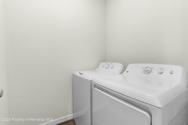 washroom featuring laundry area, washer and clothes dryer, and baseboards