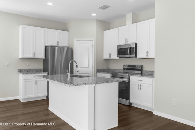 kitchen featuring a center island with sink, appliances with stainless steel finishes, white cabinets, and a sink