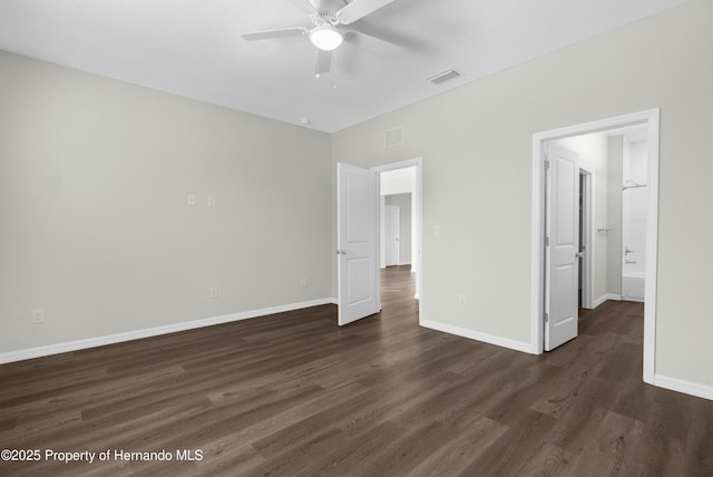 unfurnished bedroom featuring dark wood-style flooring, visible vents, and baseboards