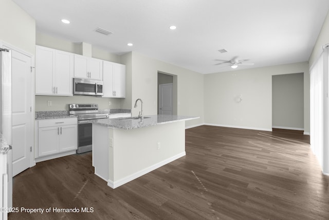 kitchen featuring a kitchen island with sink, stainless steel appliances, a sink, visible vents, and white cabinetry