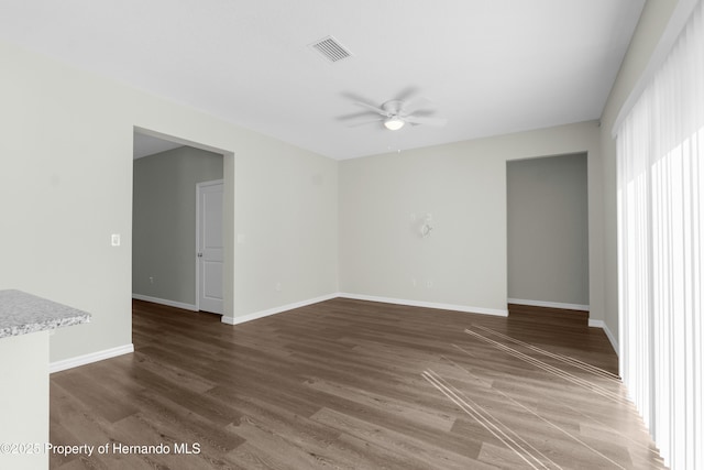 unfurnished room featuring visible vents, ceiling fan, baseboards, and wood finished floors