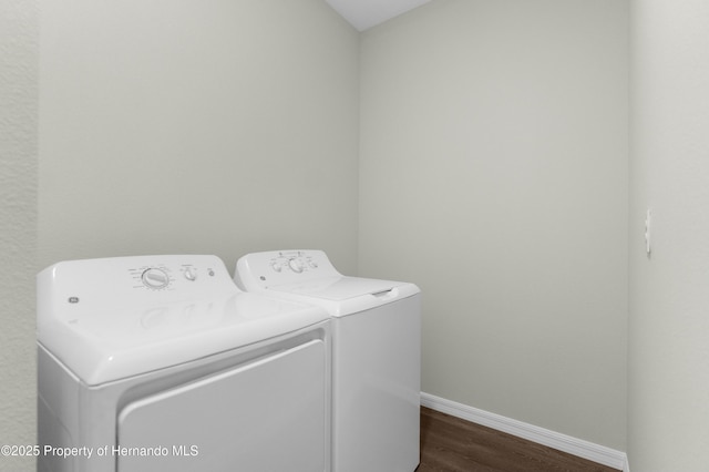 laundry room with dark wood-style floors, laundry area, washing machine and clothes dryer, and baseboards