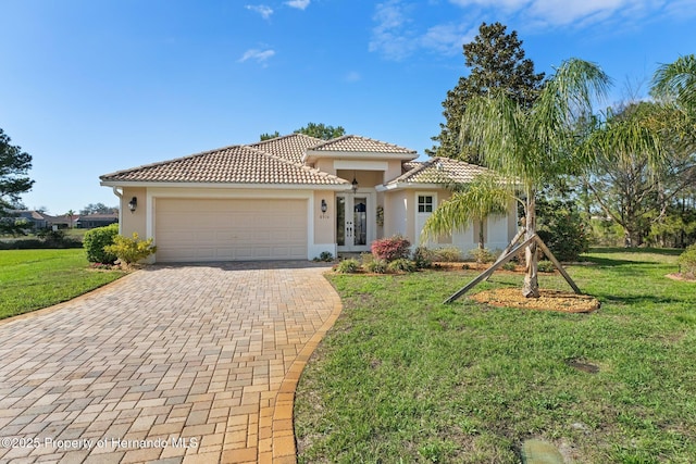 mediterranean / spanish-style home with a garage, a front yard, decorative driveway, and stucco siding