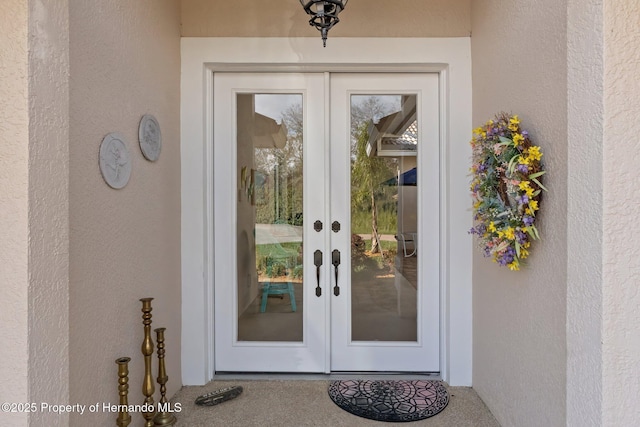 property entrance with french doors and stucco siding