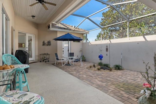 view of patio / terrace featuring ceiling fan, outdoor dining space, a lanai, and a grill