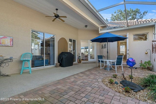 view of patio / terrace with a ceiling fan, a lanai, and area for grilling