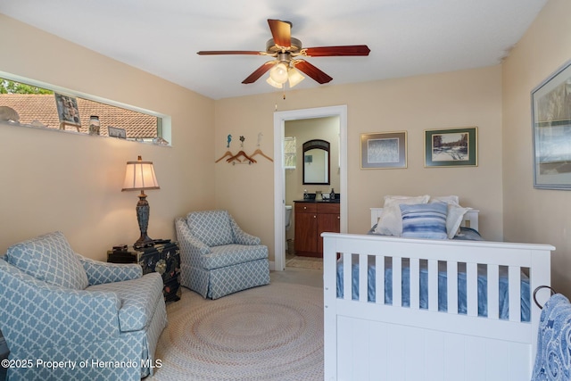 bedroom featuring ensuite bath, carpet flooring, and a ceiling fan