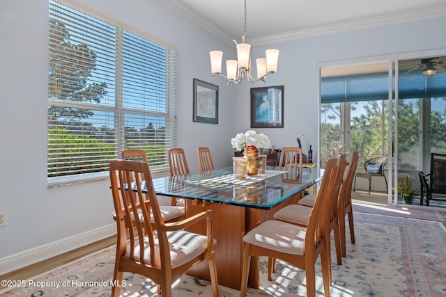 dining room with light wood finished floors, ornamental molding, a chandelier, and baseboards