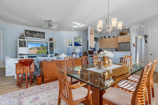 dining room featuring ceiling fan with notable chandelier, light wood finished floors, visible vents, and crown molding