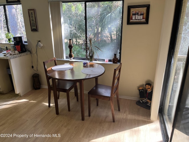 dining space featuring baseboards and light wood finished floors