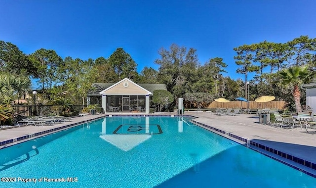 pool featuring a patio area and fence