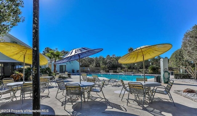 community pool featuring fence and a patio