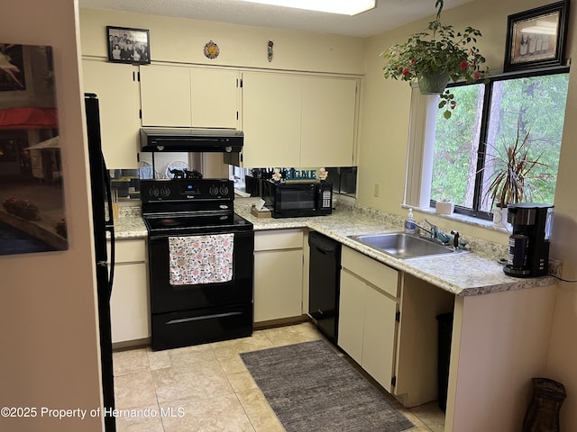 kitchen featuring light tile patterned flooring, under cabinet range hood, a sink, light countertops, and black appliances