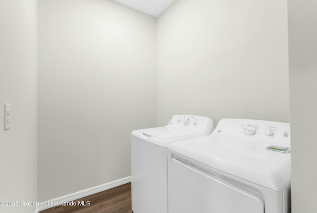 laundry room with laundry area, baseboards, dark wood-style flooring, and washer and dryer