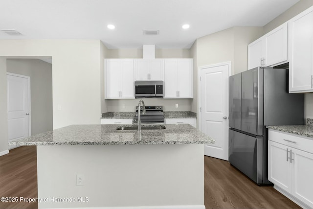 kitchen with white cabinets, a kitchen island with sink, stainless steel appliances, and a sink