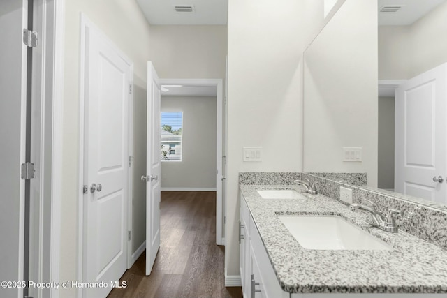 bathroom featuring visible vents, a sink, and wood finished floors