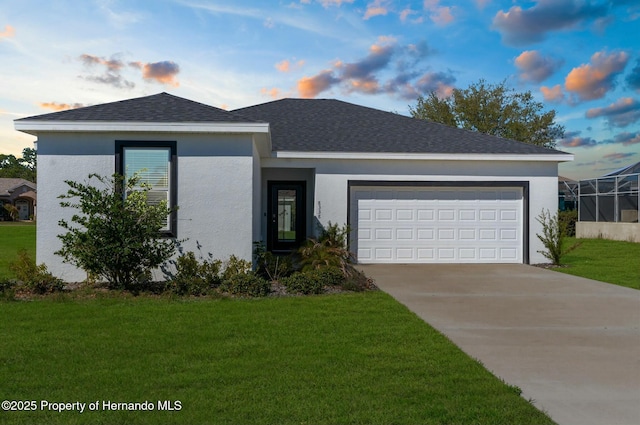 view of front facade featuring an attached garage, a front lawn, and concrete driveway