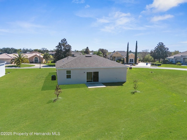 back of property featuring a residential view and a lawn