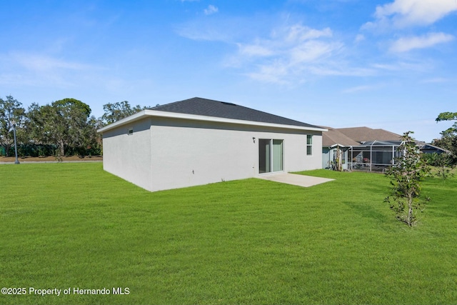 back of house featuring a lawn and stucco siding